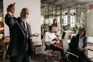 Chef i kostym instruerar sitt team på ett ljust kontor